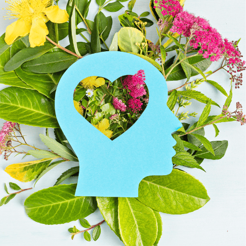 Happy Feels Good Mental Health Resources And Support Logo Button Blue Papercut Head With Heart Cut Out On Top Of Flowers And Leaves